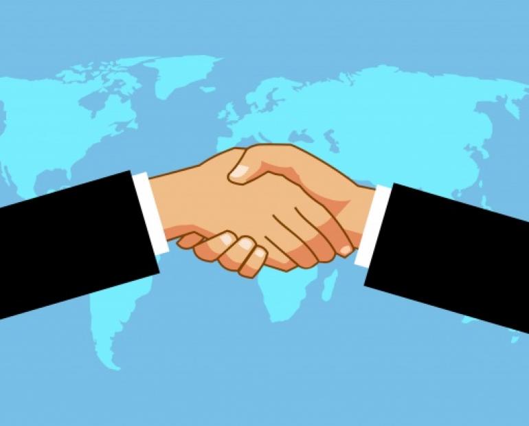 Picture symbolizing trust and brace through a handshake over picture of world