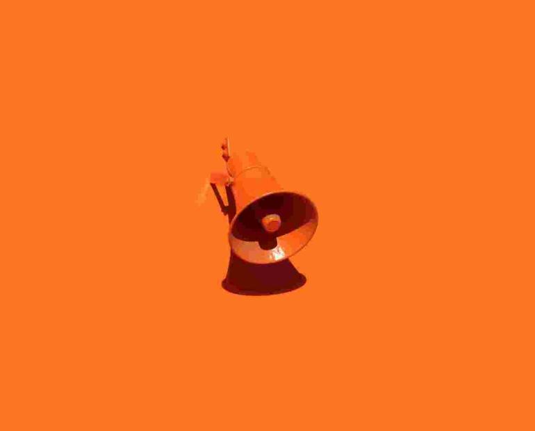 An orangde loudspeaker, on an orange background.