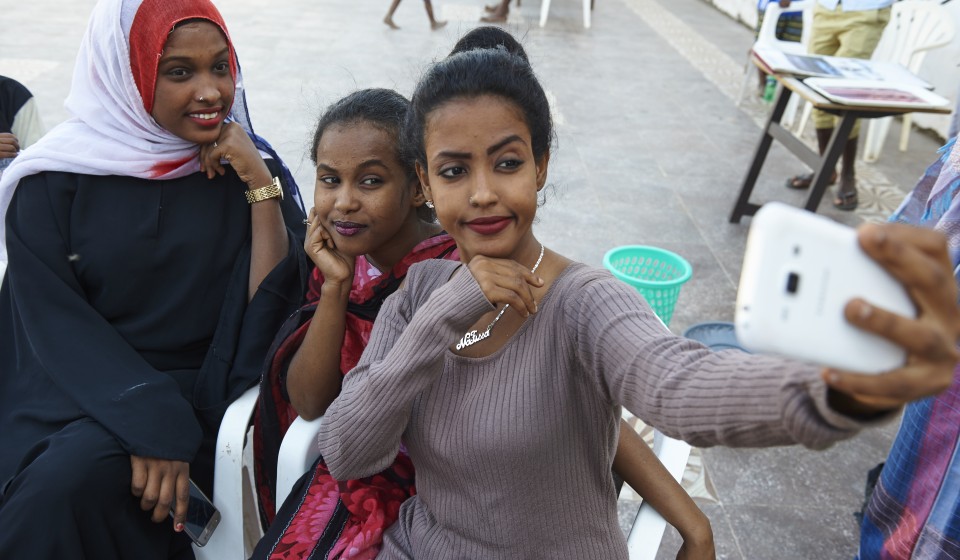 Three young girls take a selfie during a life skills training session.