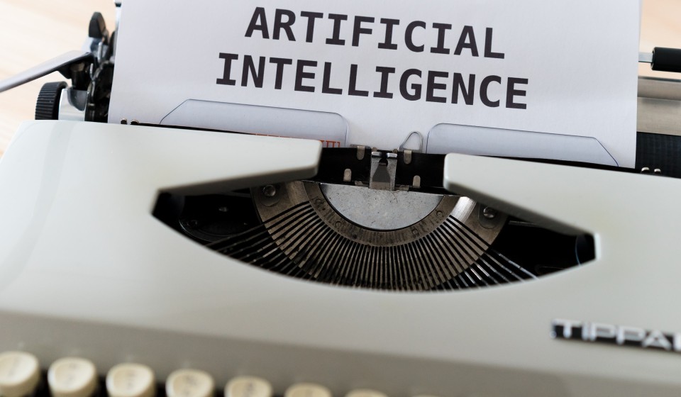 Typewriter with a piece of paper that says "Artificial Intelligence"