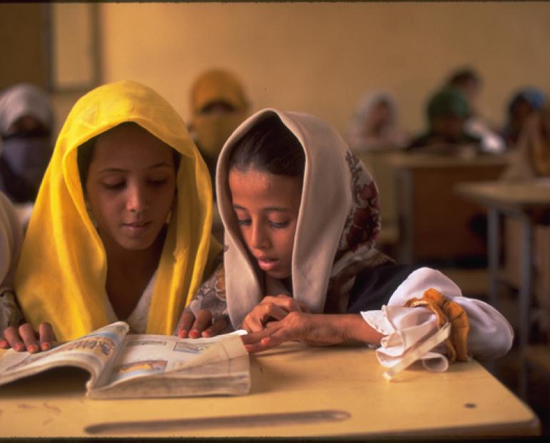 two girls share a book in a class at the local primary school in the village of Kwanawis 