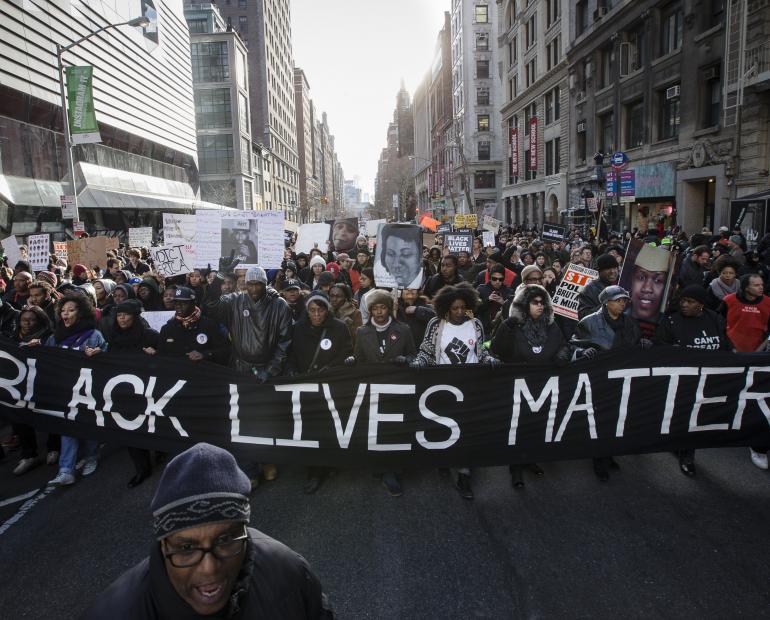 a black lives matter protest where people are marching on a street with a black lives matter sign
