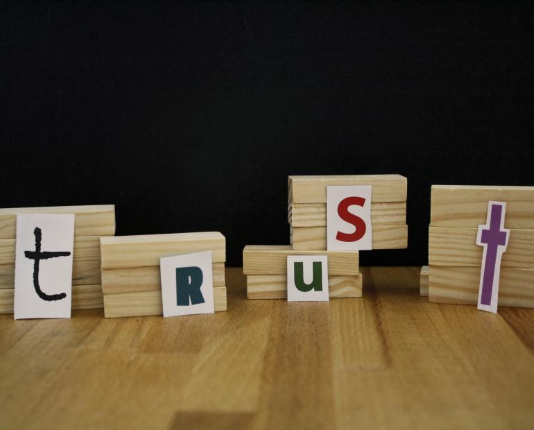 Some pieces of wood with the letters of the word "Trust" on them.