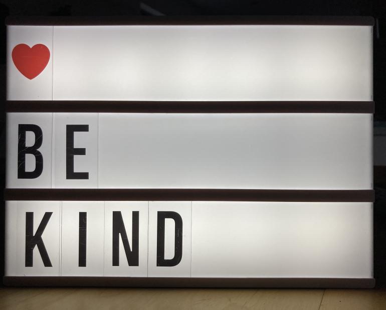 "Be kind" on a lightbox with a heart emoji