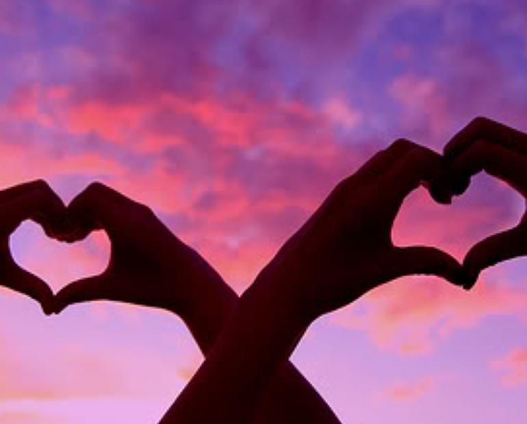 Hearts made with hands and a sunset