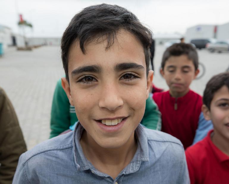 Children at the Kahramanmaras Temporary Accommodation Center in Turkey, children play outside. The camp currently hosts more than 11,000 Syrian refugees, half of them children. It offers schooling for 3,700 children and training opportunities for young people.