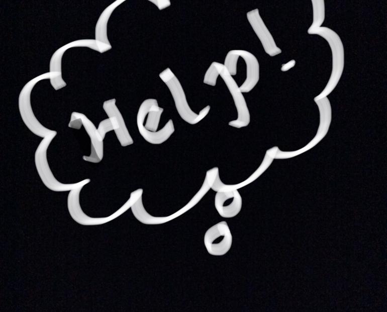 Black background where it is written “Help!” with white ink.