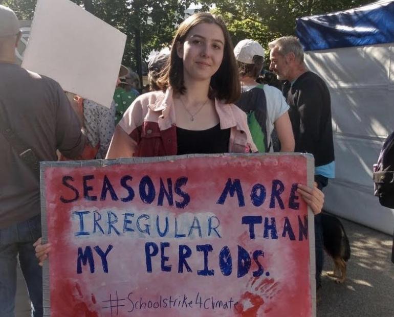 Molly Hucker is pictured at a #schoolstrike4climate protest as part of the global September 2019 climate strikes. Molly holds a sign saying "Seasons more irregular than my periods".. 
