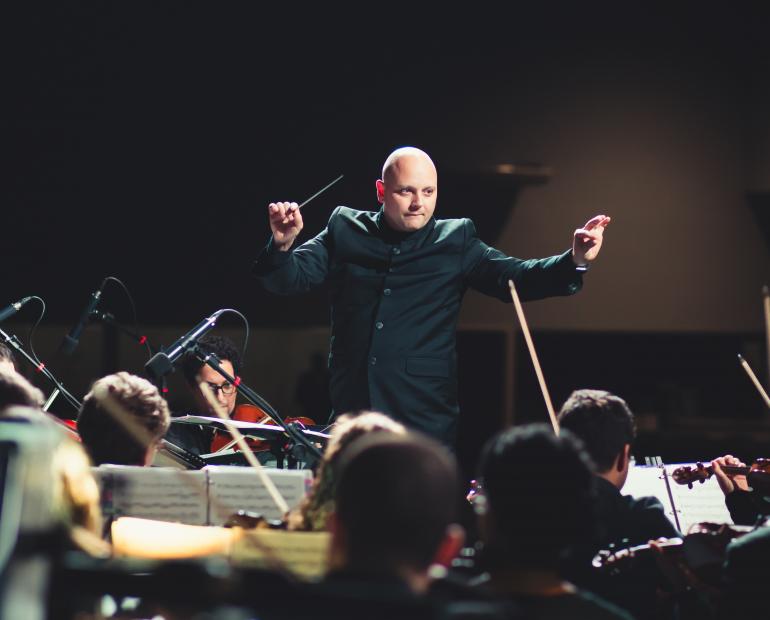A maestro leads an orchestra