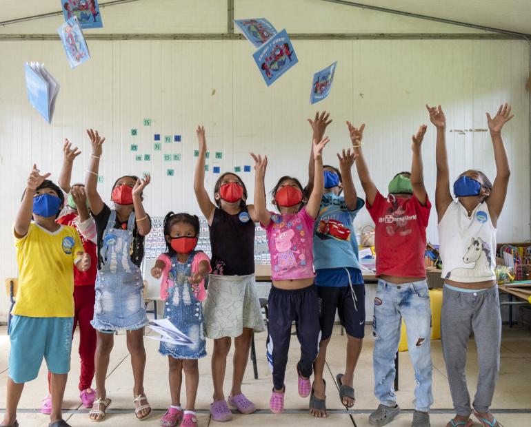 kids throwing books in the air at school in Ecuador