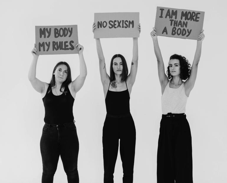 Women Holding Signboards saying: "my body, my rules", "no sexism", and "I am more than a body".