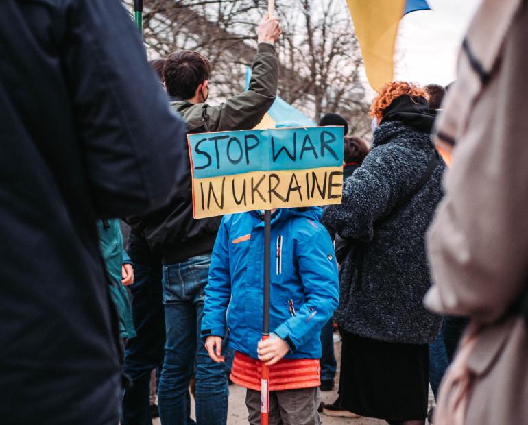 Ukrainian child holding poster and prostesting against war