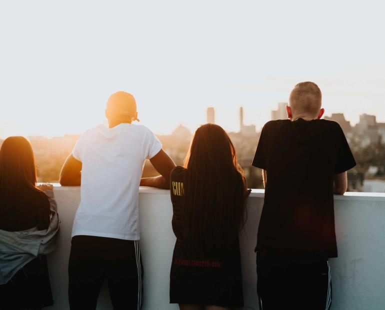 A group of young people staring at the sunset.