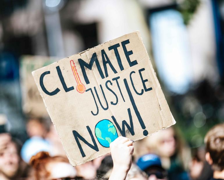 Climate justice now reads a placard at a protest.