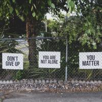 Signs that say "Don't give up", "You are not alone", "You matter"