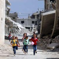Children running amid a war destructed street