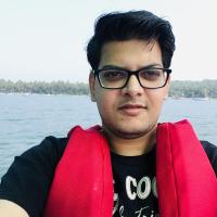 It is a photo of me, sitting in boat in Goa. clean shaved wearing specs and safety vest.