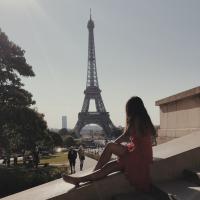 A picture of me sitting on the stairs facing the Eiffel Tower in Paris, France.