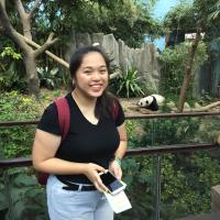 A smiling 19 year old woman beside a cute panda named Kai Kai