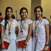 three schoolgirls with gold medals