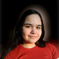 In the image you can see a dark-haired girl wearing a red T-shirt; The background of the image is black;
